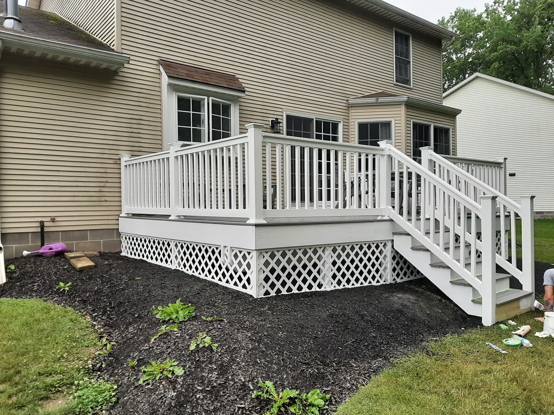 After: deck upgraded with white railings, fresh decking and lattice skirting