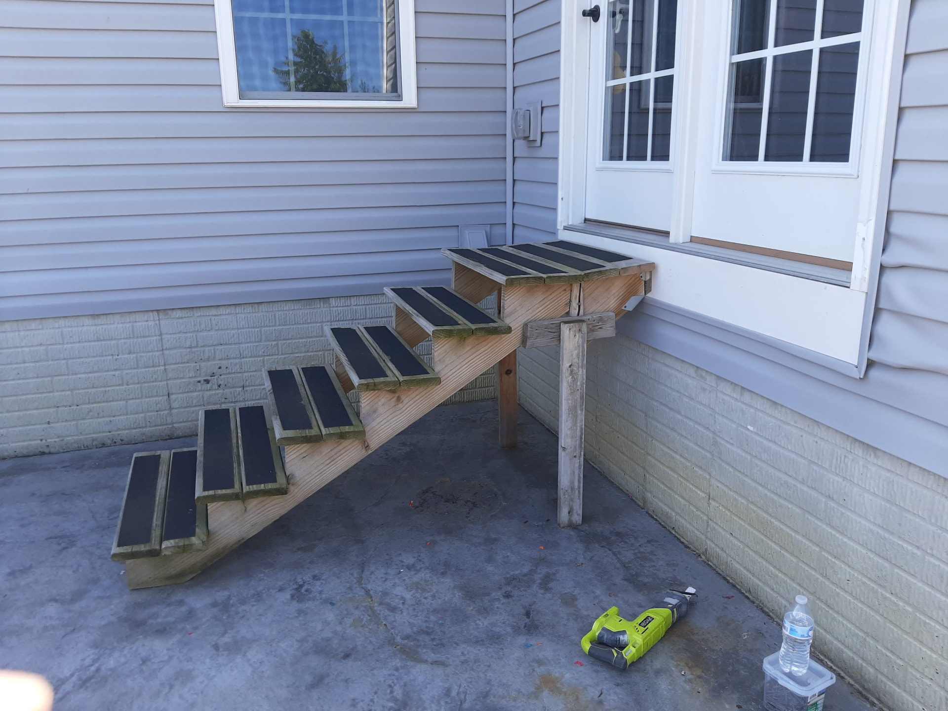 Before: weathered open-riser side stairs with black treads and a single support post