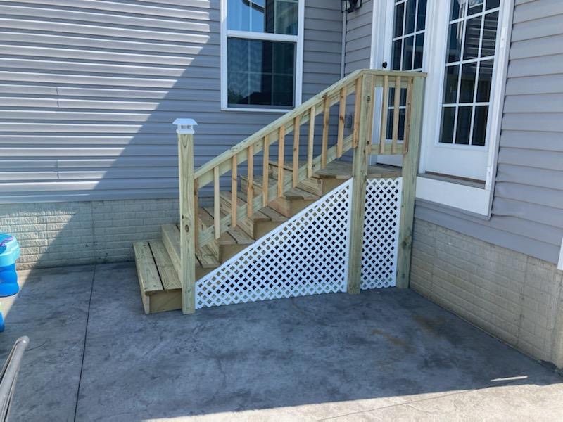 After: rebuilt side entry stairs with solid framing, railings and white lattice skirting