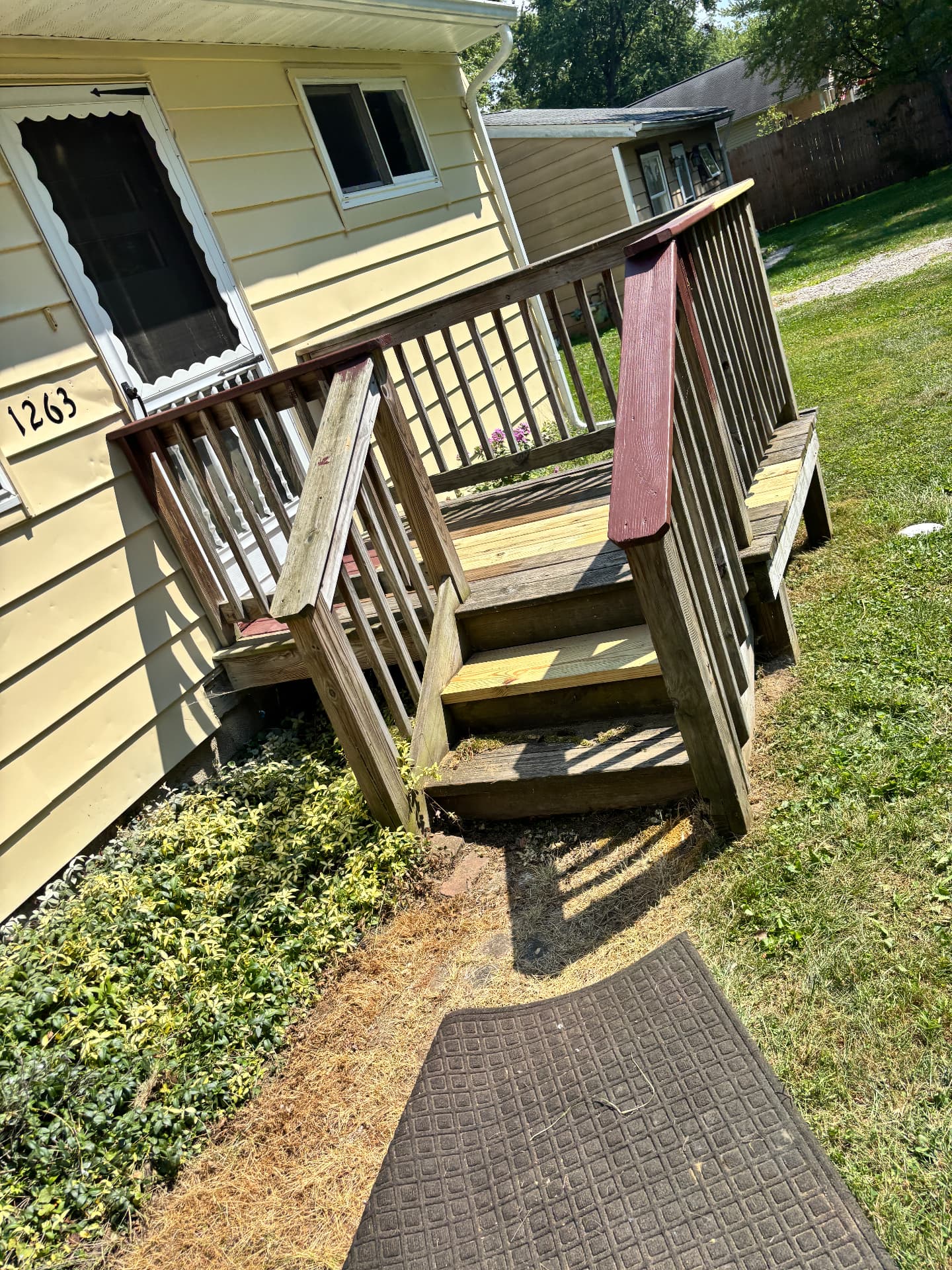 Before: weathered wood porch with split decking and loose railings