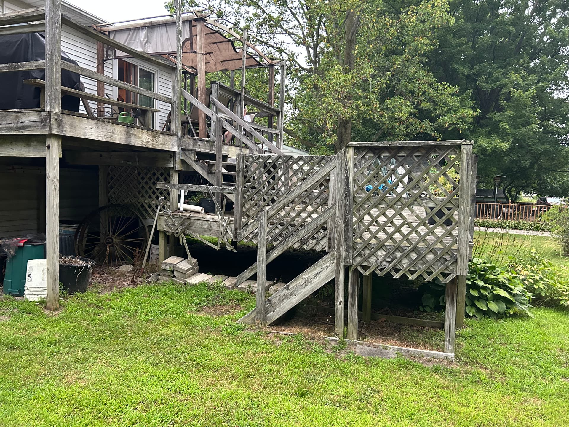 Before: aged two-level deck with weathered railings and lattice