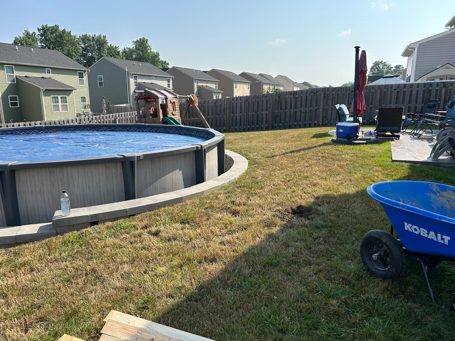 Before: above-ground pool with bare grass yard and no deck
